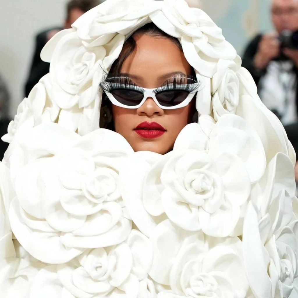 Rihanna faz referência aos últimos lançamentos da marca Fenty Beauty, com destaque nos cílios volumosos e batom vermelho icônico (Foto: Divulgação)